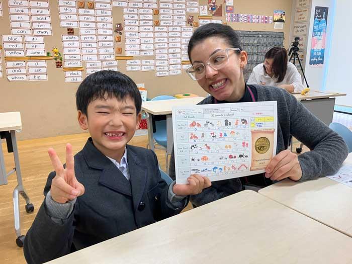 スウェーデン出身の留学生とGCチャレンジを行い、合格メダルをもらった笑顔の一年生